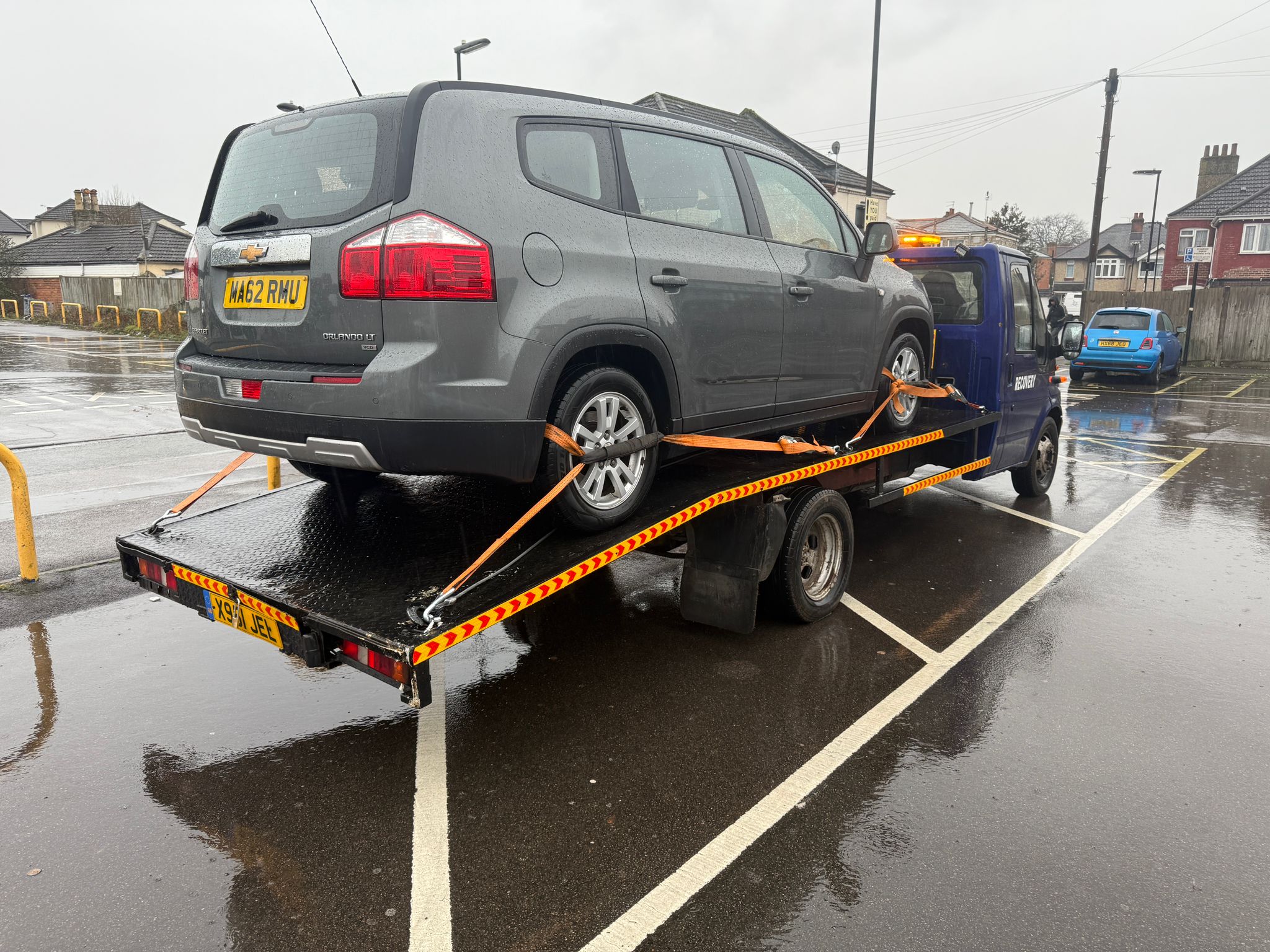 Tow truck loading a stranded car onto a flatbed